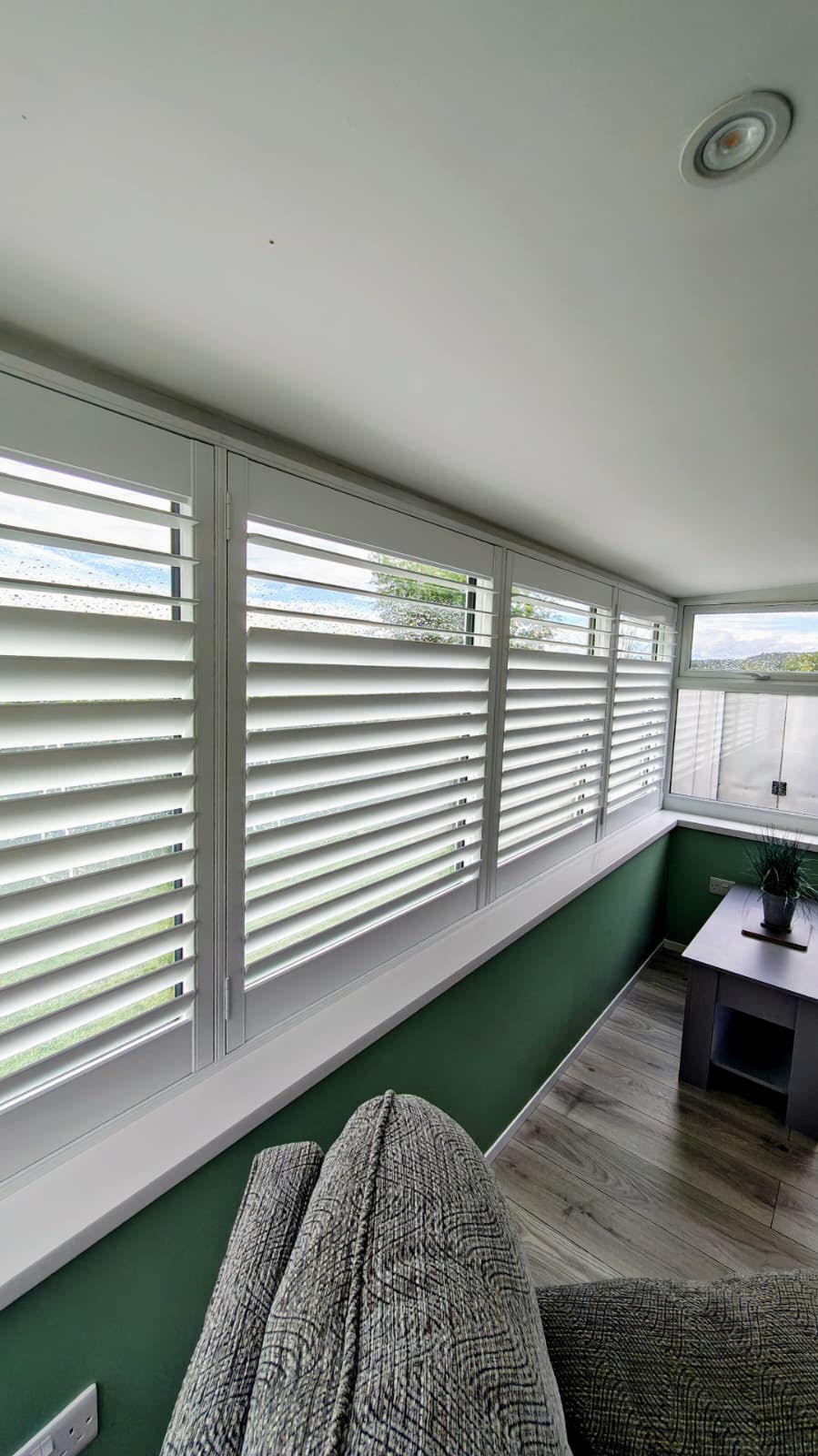 Full Height white shutters wrapping a light-filled sunroom