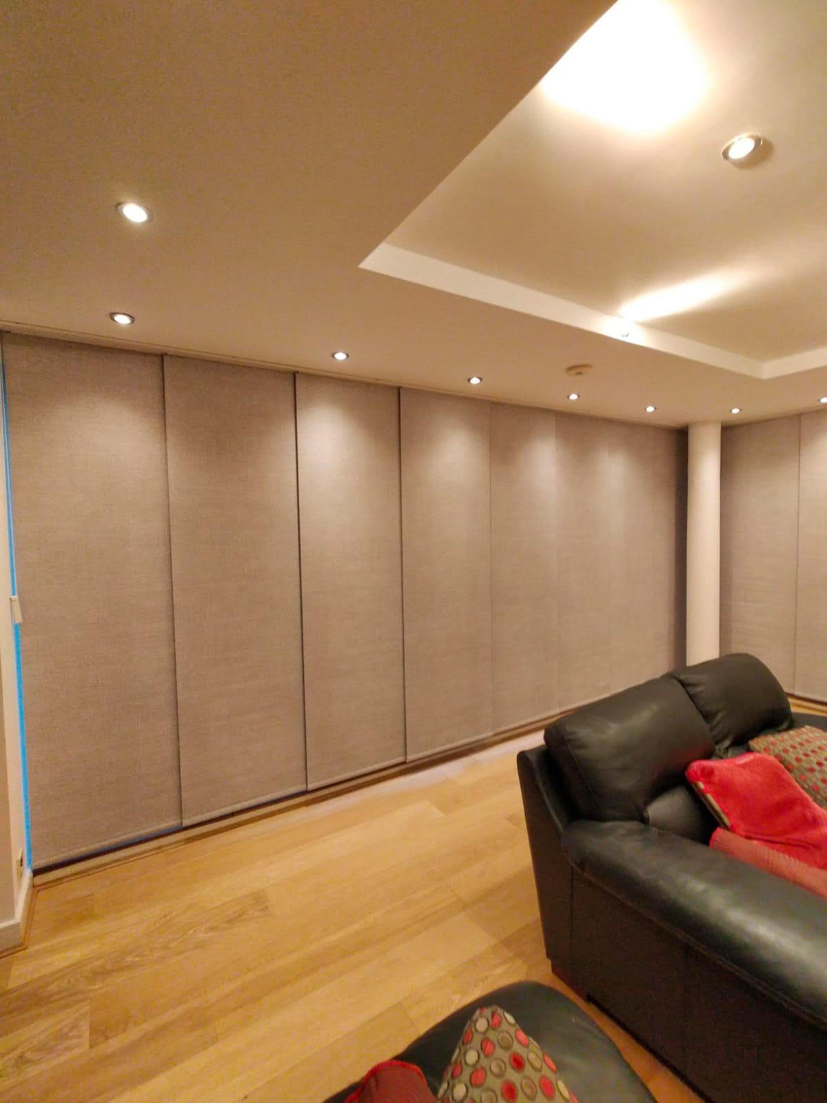 Full-wall grey panel blinds in a contemporary lounge