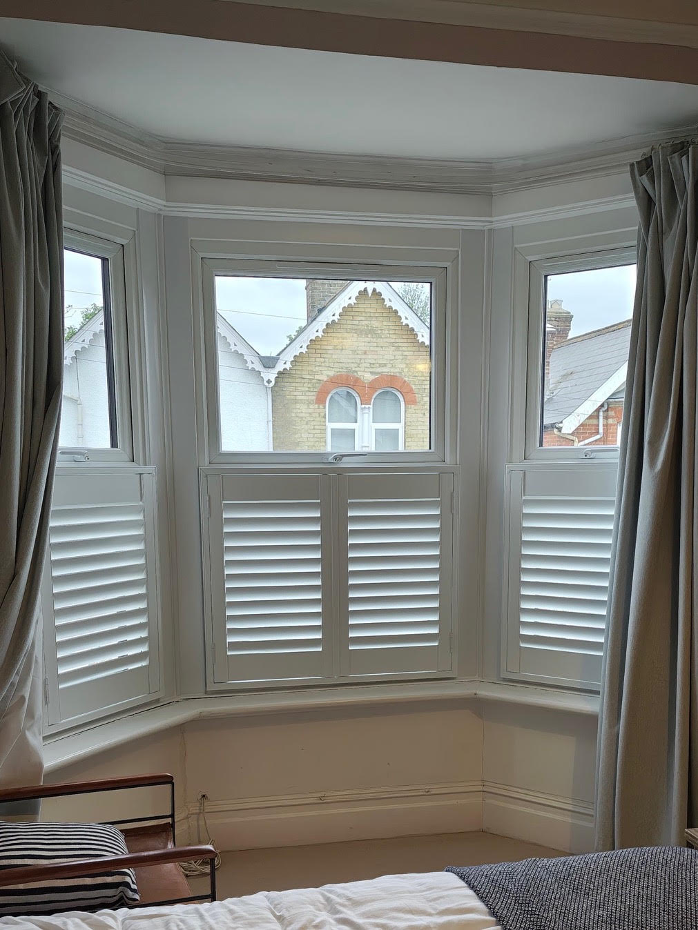 White Café Style shutters set into a period bay window