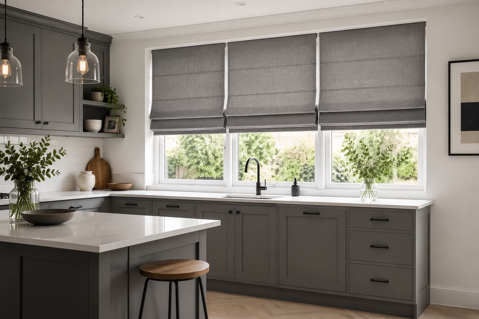 Grey Roman blinds in a modern shaker kitchen with white worktops and pendant lighting