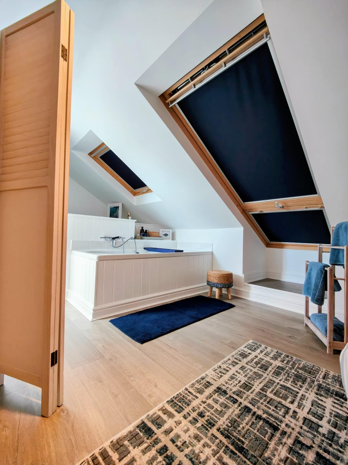 Navy blackout Velux blinds in a light loft bathroom