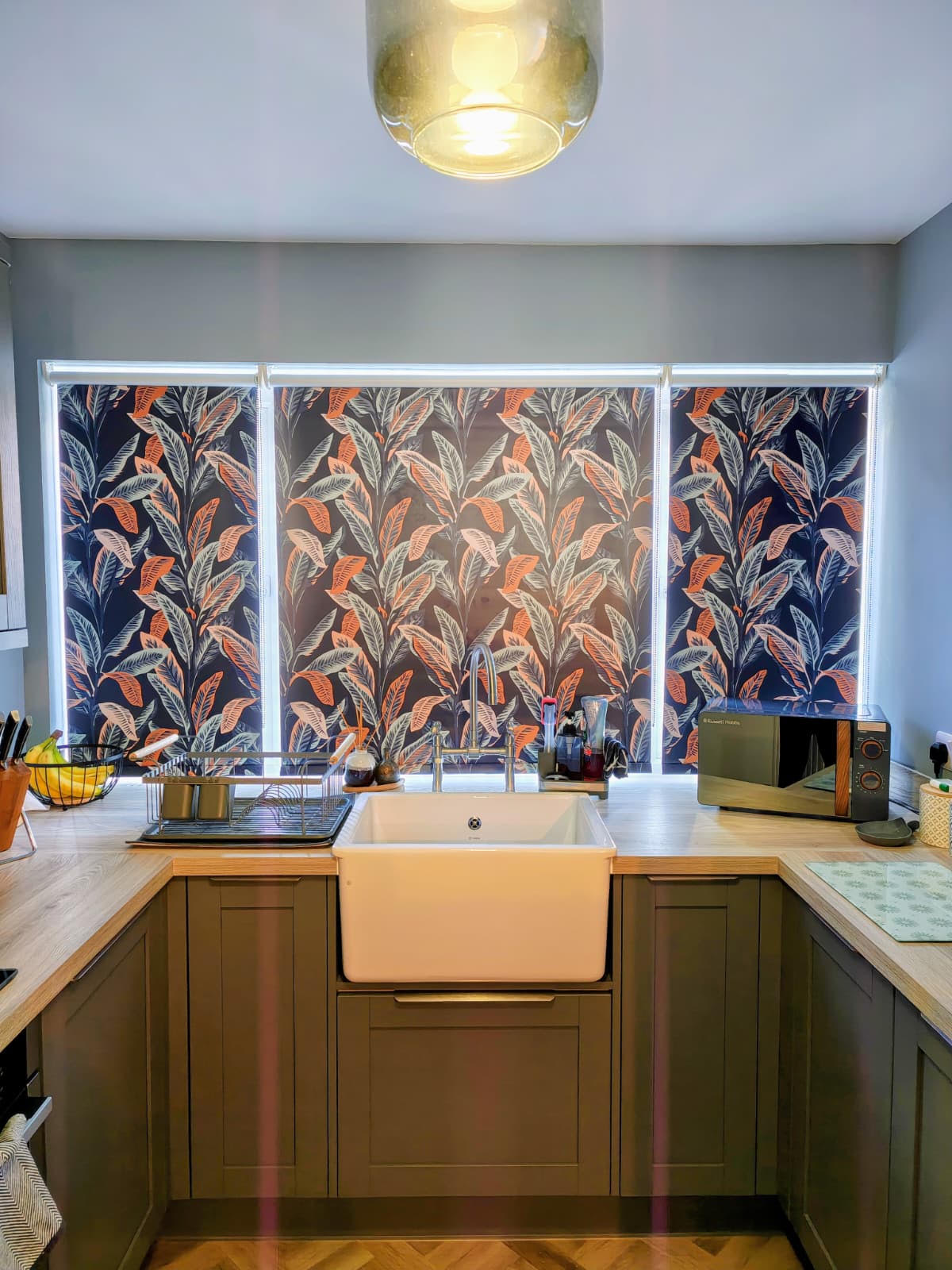 Bold navy and coral leaf roller blinds above a kitchen sink