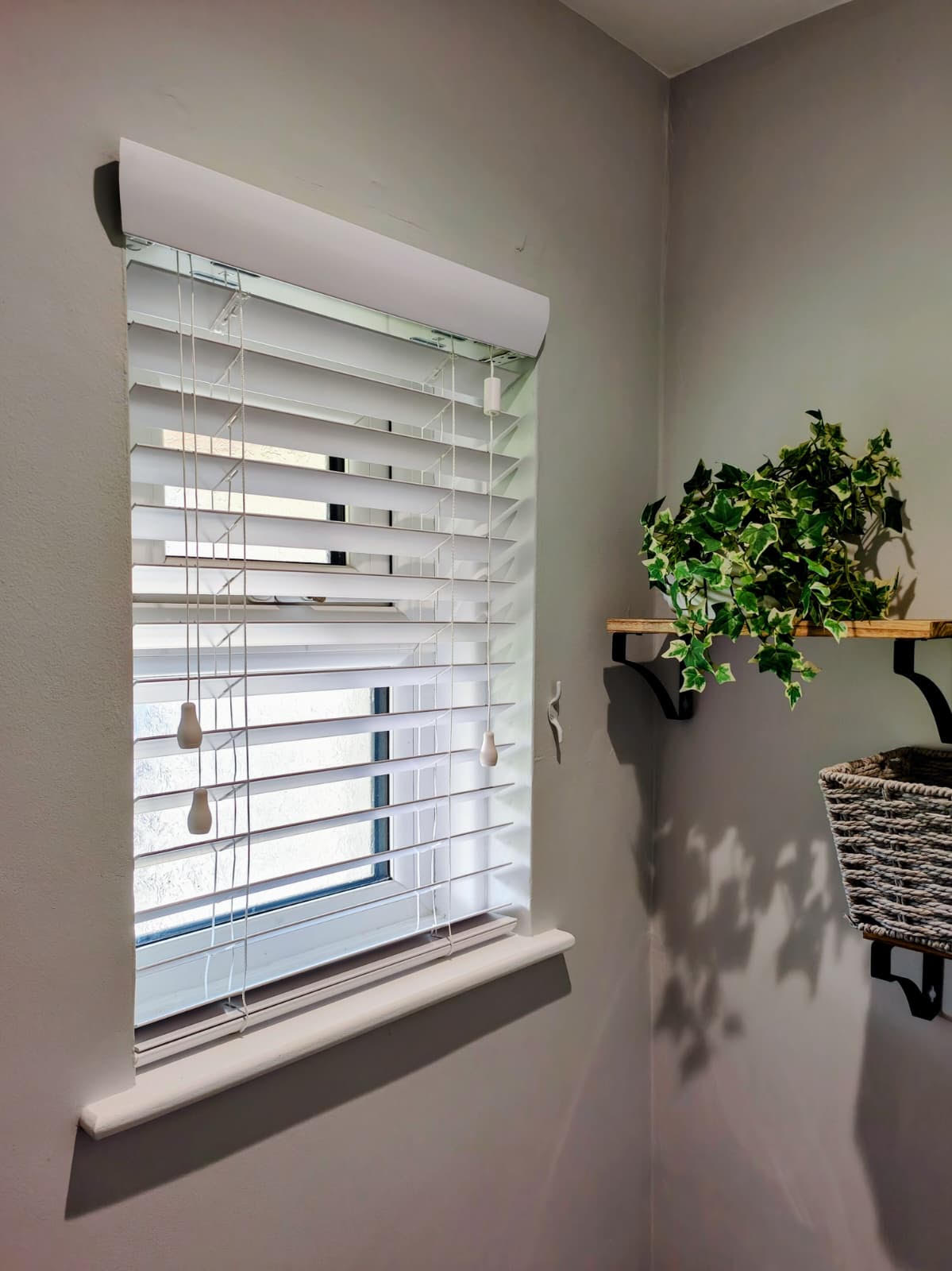 White wooden Venetian blind in a bright utility room